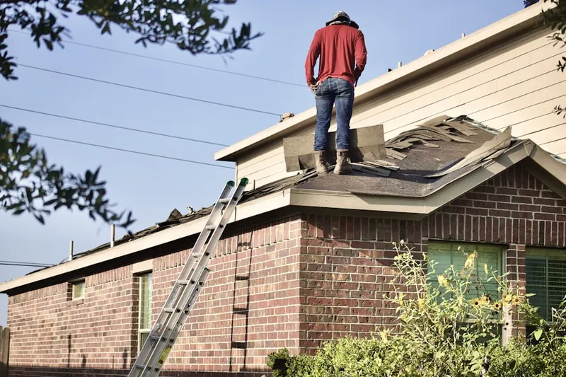 Professional roofer working on a residential roof in West Little River